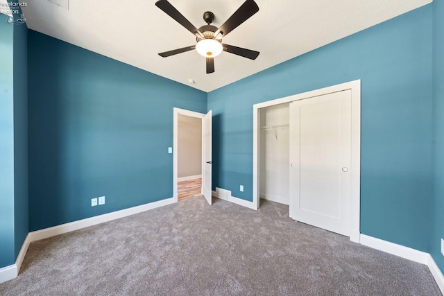 unfurnished bedroom featuring carpet, a closet, ceiling fan, and baseboards