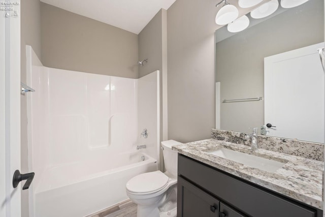 bathroom featuring shower / washtub combination, vanity, toilet, and wood finished floors