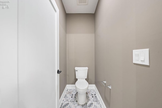 bathroom featuring tile patterned flooring, baseboards, visible vents, and toilet