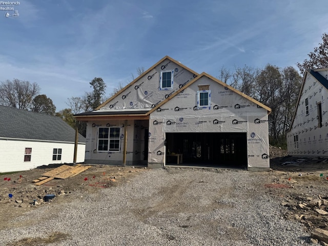 property under construction with a garage and dirt driveway