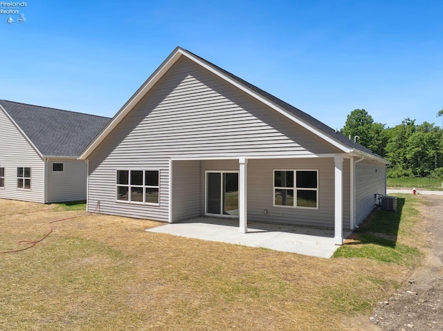 rear view of house featuring a patio area, a lawn, and central AC unit