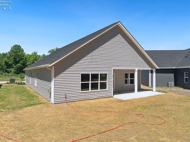 rear view of house featuring a lawn, a patio area, and cooling unit