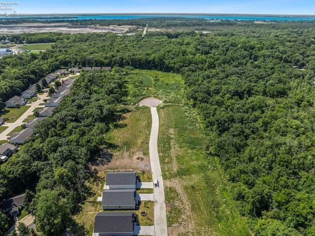 drone / aerial view featuring a wooded view