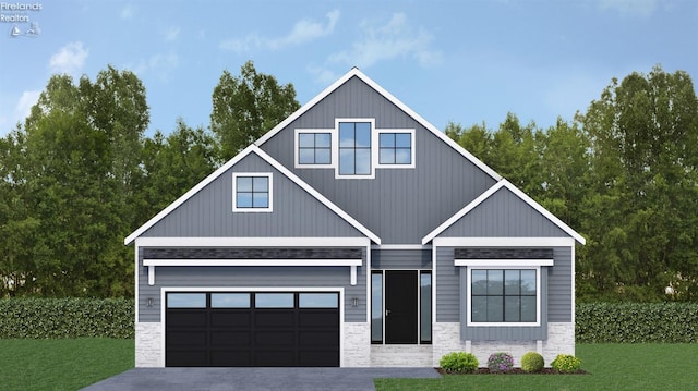 view of front of home featuring a garage, a front yard, stone siding, and concrete driveway