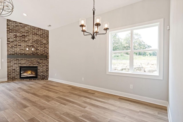 unfurnished living room featuring lofted ceiling, light wood-style flooring, recessed lighting, a fireplace, and baseboards