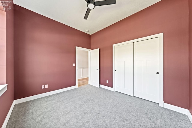 unfurnished bedroom with carpet floors, ceiling fan, baseboards, and a closet