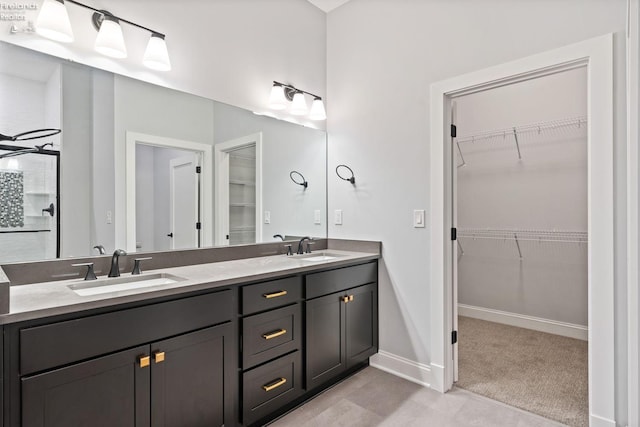 full bathroom featuring double vanity, a spacious closet, and a sink