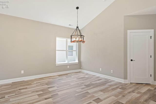 spare room with a notable chandelier, visible vents, baseboards, vaulted ceiling, and light wood-style floors