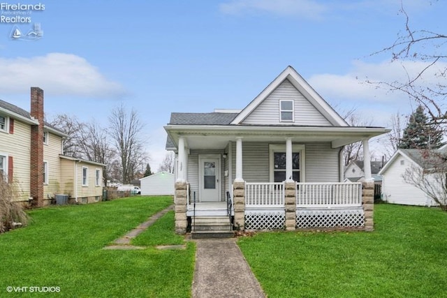 bungalow featuring a porch, a front yard, and cooling unit