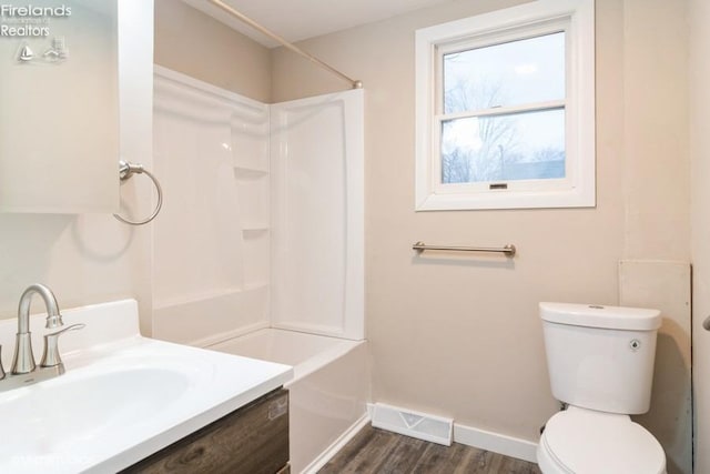 full bathroom featuring washtub / shower combination, vanity, wood-type flooring, and toilet