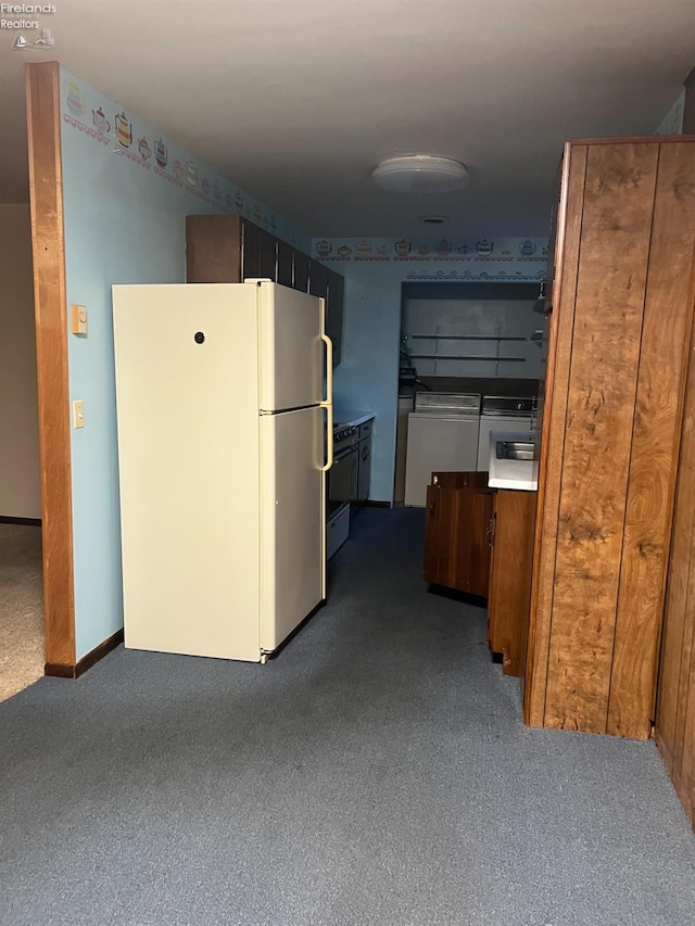 kitchen with carpet flooring, white refrigerator, and washing machine and dryer