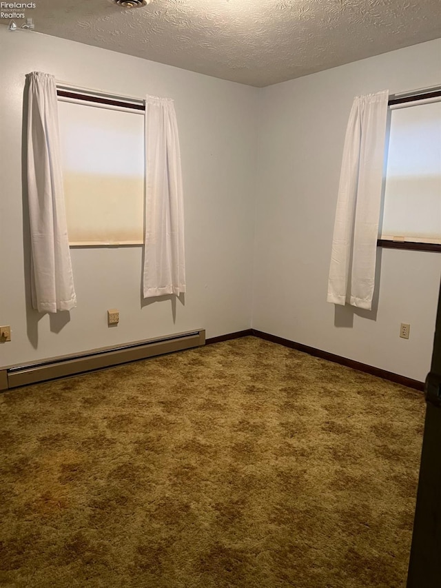 empty room with carpet, a baseboard radiator, and a textured ceiling