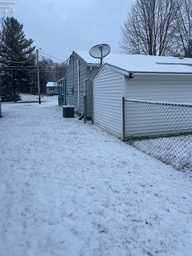 view of snow covered exterior with cooling unit