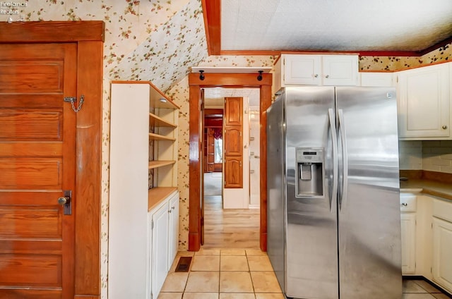 kitchen featuring white cabinets, stainless steel refrigerator with ice dispenser, and light tile patterned flooring