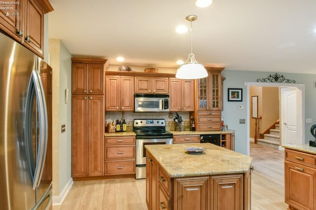 kitchen with decorative backsplash, stainless steel appliances, light hardwood / wood-style flooring, a kitchen island, and hanging light fixtures