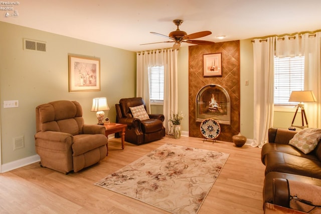 living area with ceiling fan, light hardwood / wood-style floors, and a wealth of natural light