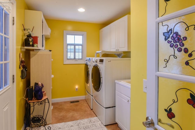 laundry area with cabinets, separate washer and dryer, and light tile patterned floors