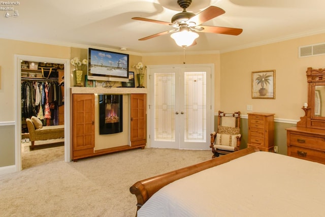 carpeted bedroom with crown molding, french doors, and ceiling fan