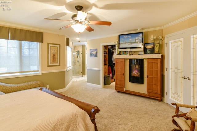 bedroom with light colored carpet, ceiling fan, crown molding, and ensuite bathroom