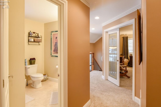 hall with light colored carpet and crown molding