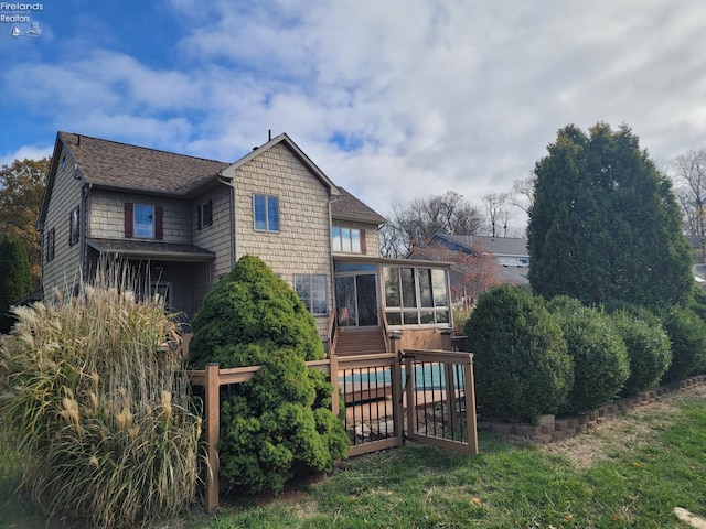 back of property featuring a sunroom and a wooden deck