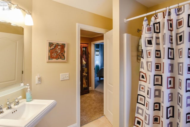 bathroom with a shower with curtain, sink, and ornamental molding