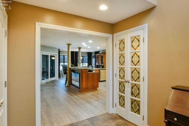 bar featuring light hardwood / wood-style flooring and stainless steel dishwasher