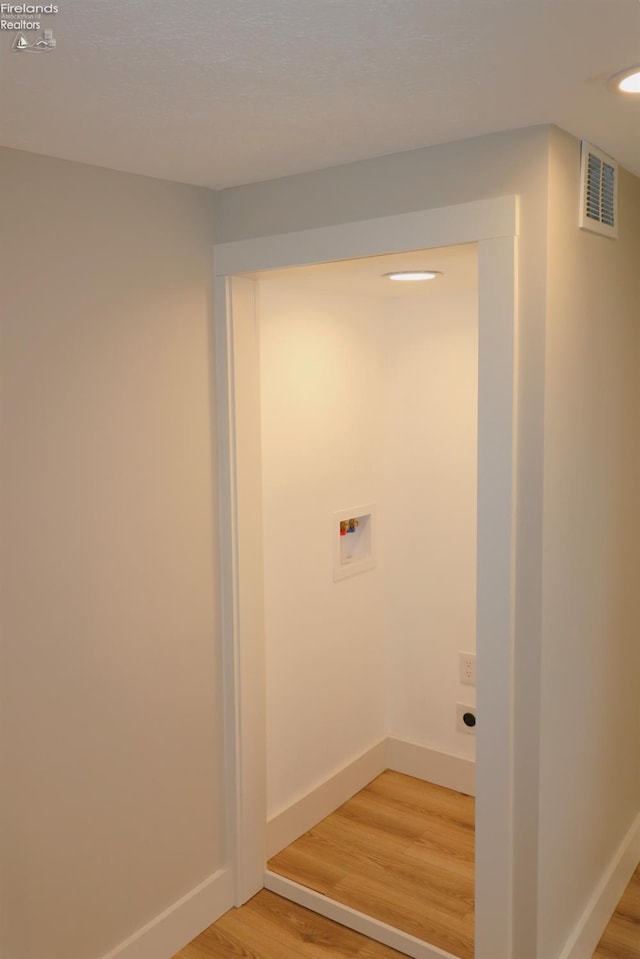 washroom with hardwood / wood-style floors and washer hookup