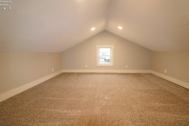 additional living space with carpet and vaulted ceiling