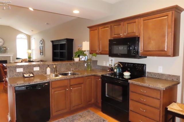 kitchen featuring light stone countertops, sink, kitchen peninsula, vaulted ceiling, and black appliances