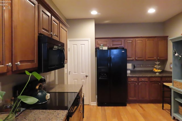 kitchen featuring light hardwood / wood-style flooring and black appliances