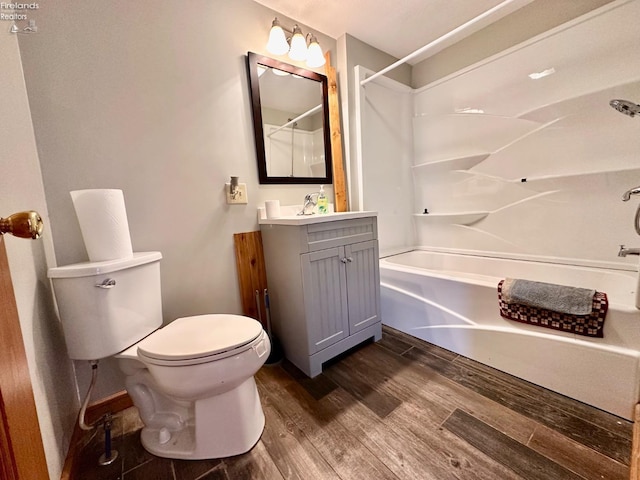 full bathroom featuring toilet, wood-type flooring, vanity, and bathtub / shower combination