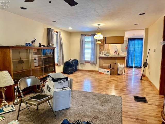 living room featuring ceiling fan and light hardwood / wood-style flooring