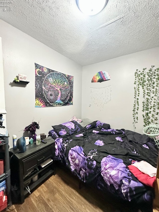 bedroom with hardwood / wood-style floors and a textured ceiling