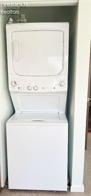 clothes washing area featuring stacked washer / dryer