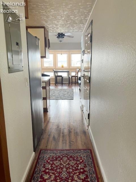 corridor with electric panel, crown molding, and dark hardwood / wood-style flooring