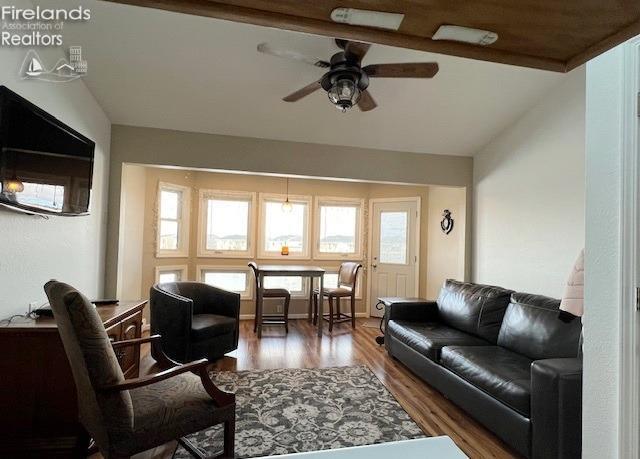 living room with ceiling fan, hardwood / wood-style floors, and lofted ceiling