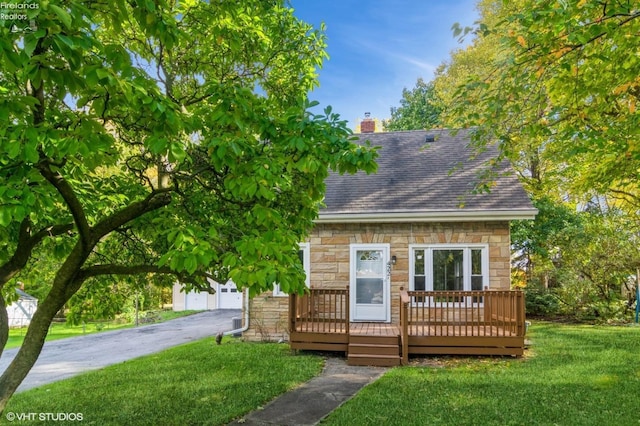 view of front of property featuring a deck, a front lawn, and a garage