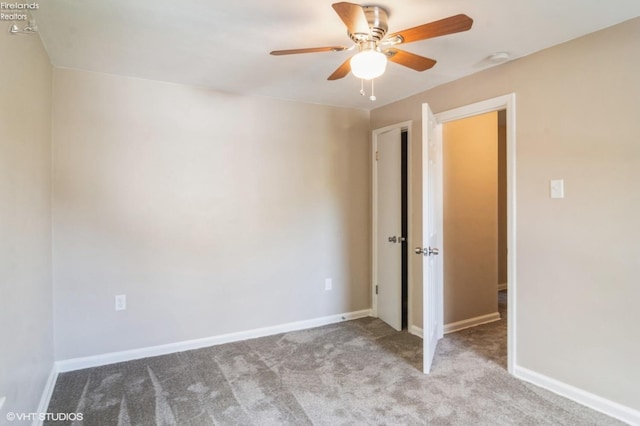 carpeted spare room with ceiling fan