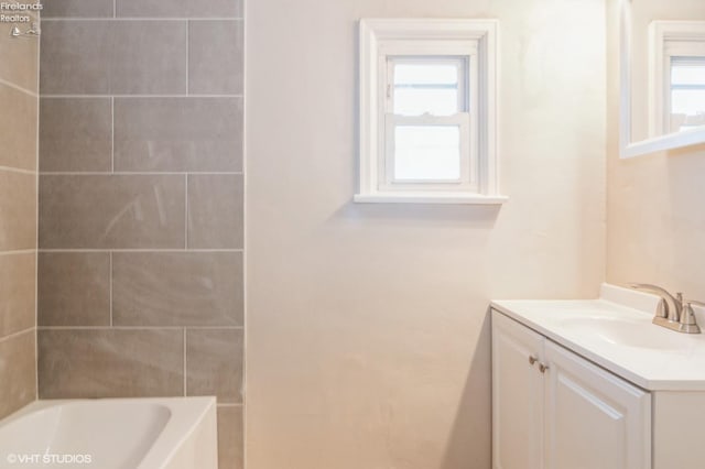 bathroom with plenty of natural light, a tub to relax in, and vanity