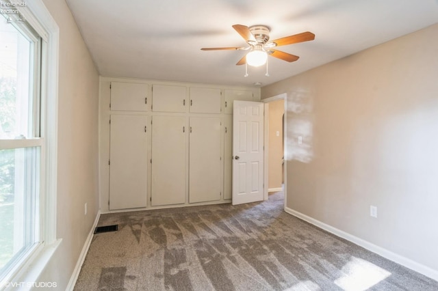 unfurnished bedroom with ceiling fan, light colored carpet, and a closet