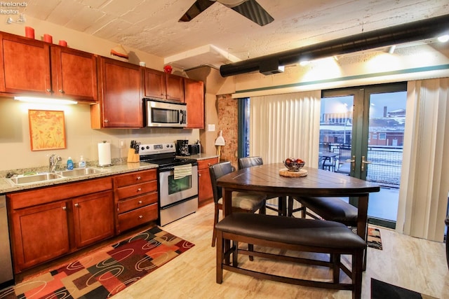 kitchen featuring light hardwood / wood-style floors, sink, light stone countertops, and stainless steel appliances