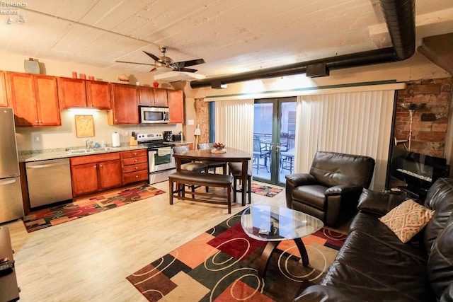 kitchen with ceiling fan, sink, french doors, stainless steel appliances, and light hardwood / wood-style flooring