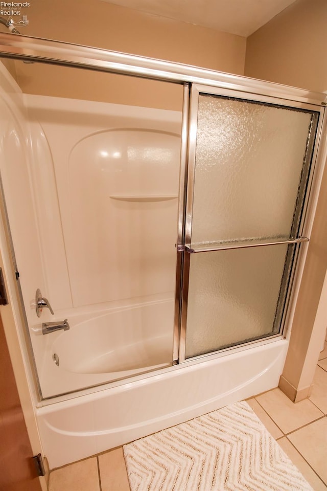 bathroom with tile patterned floors and bath / shower combo with glass door