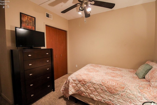 bedroom featuring ceiling fan, a closet, and light colored carpet