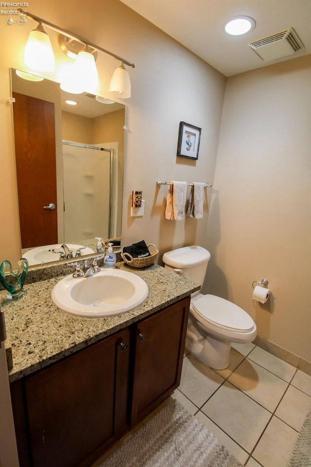 bathroom with tile patterned flooring, vanity, an enclosed shower, and toilet