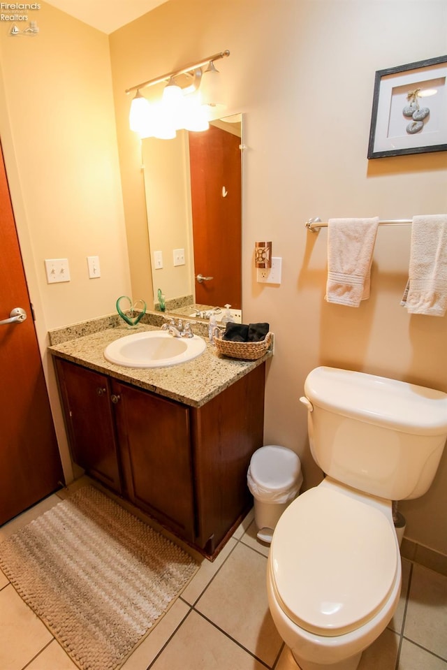 bathroom featuring toilet, vanity, and tile patterned floors