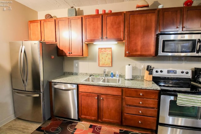 kitchen featuring appliances with stainless steel finishes, light stone counters, and sink