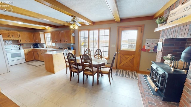 dining space with beam ceiling, a textured ceiling, and ceiling fan