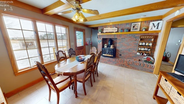 dining area featuring beamed ceiling, ceiling fan, and a wood stove